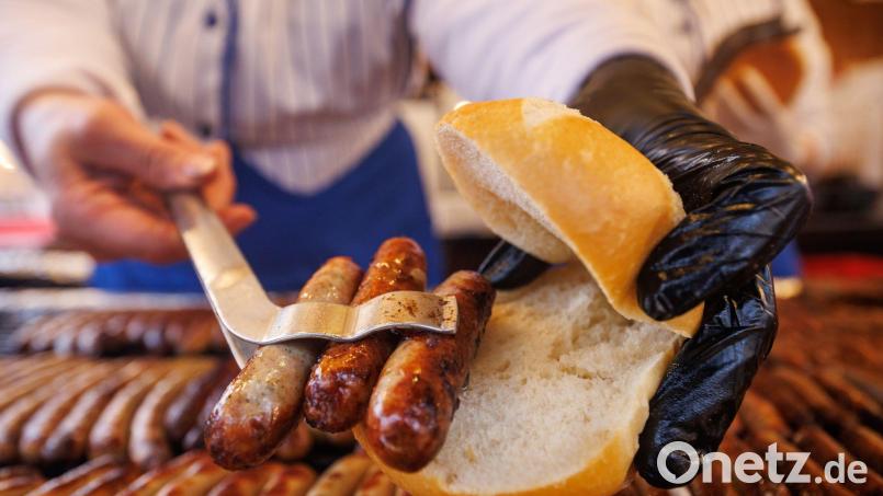 Nürnberger Rostbratwürste liegen in einem Brötchen. Bild: Daniel Karmann/dpa/Archiv