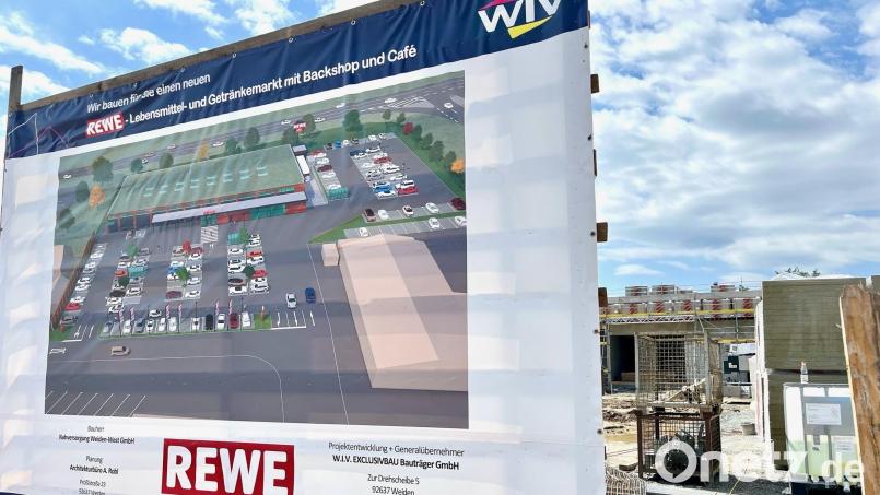 Lebensmittel- und Getränkemarkt mit Backshop und Café: Auf dem Plakat ist zu sehen, wie das Areal des neuen Rewe-Marktes in Weiden künftig gestaltet sein wird. Bild: Gabi Schönberger