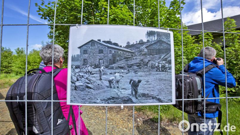 Einen eindrucksvollen Moment fing Josef Schell mit der Kamera ein: Fotografen sehen sich auf dem Gelände des ehemaligen KKZ-Steinbruchs um. Am Bauzaun hängt eine alte Aufnahme, die den Bereich vor mehr als 80 Jahren zeigt. Bild: Josef Schell/exb