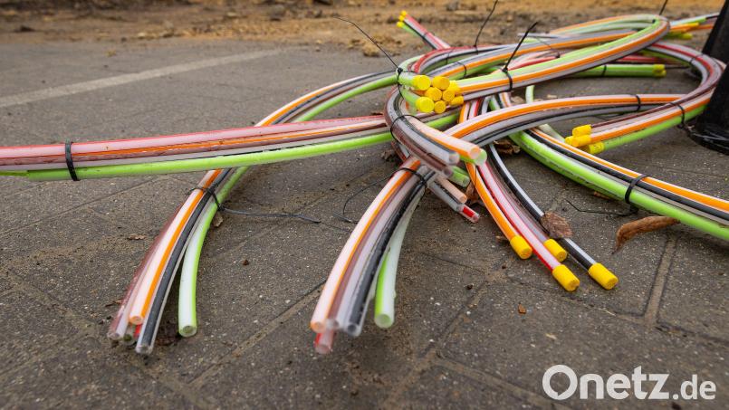 Glasfaserkabel, die in einem Wohngebiet verlegt werden, liegen auf dem Boden. In Weiden baut die Telekom das Glasfasernetz nach und nach aus. Noch in diesem Jahr soll der erste von drei Bauabschnitten abgeschlossen werden. Symbolbild: James Arthur Gekiere/dpa