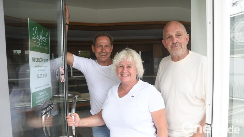 Auf dem Plakat an der ehemaligen Bäckerei Retzer steht es: Ab dem 2. Juli eröffnet dort der &quot;Dorfbeck&quot; aus Reuth bei Erbendorf. Bäckermeister Thomas Retzer (links) und Andrea Retzer übergeben an Geschäftsführer Peter Höcht. Bild: Gabi Schönberger