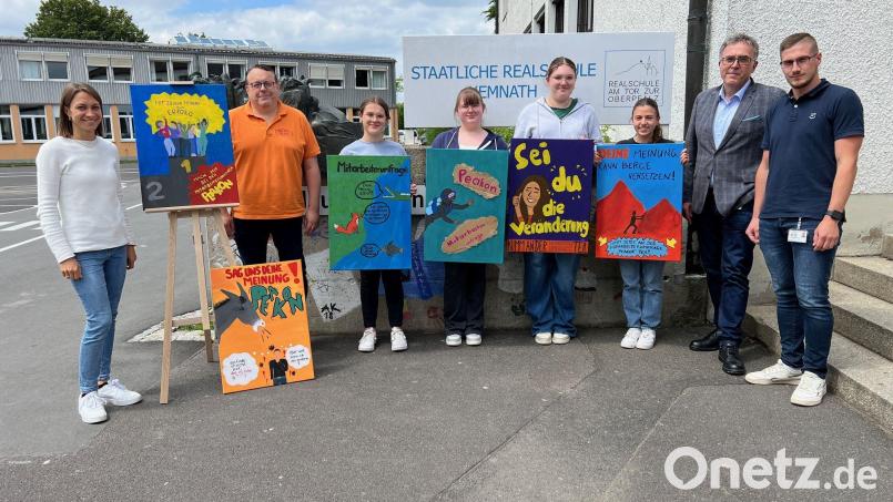 Studienrätin Elisabeth Vogel (links neben den Bildern von Magdalena Sturm und Lina Hirschke), Georg Fütterer von der gleichnamigen Kemnather Schreinerei, Sophie Scharf, Milena Grabowski, Eva Kießling, Valentina Skalsky sowie Michael Schneider und Michael Diepold von Siemens Healthineers. Bild: Elisabeth Vogel/RTO/exb