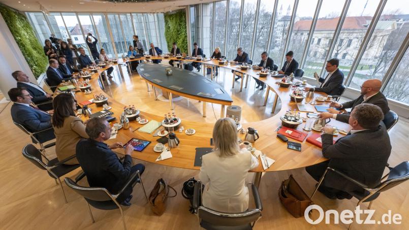 Die Minister und der Ministerpräsident sitzen zu Beginn der Sitzung des bayerischen Kabinetts gemeinsam am ovalen Tisch der bayerischen Staatskanzlei. Bild: Peter Kneffel/dpa