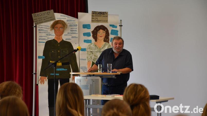 Harald Grill liest vor drei Klassen des Stiftland-Gymnasiums. Im Hintergrund: Schülerarbeiten zu der Lektüre. Bild: Stiftland-Gymnasium/exb