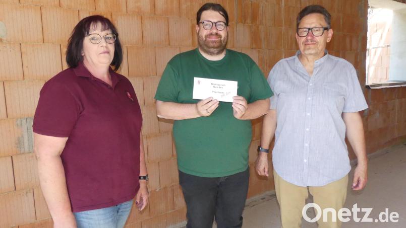Die Übergabe der Spende verbindet Pfarrer Ernstberger (Mitte) mit einem informativen Rundgang durch die Baustelle. Bild: rn
