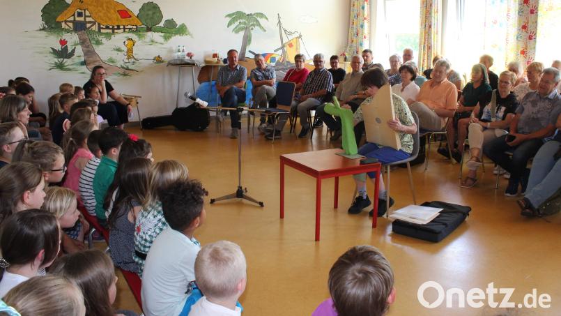 Die Kinder hören aufmerksam zu, als die Großeltern ihre Instrumente vorstellen und darauf spielen – wie hier eine Oma mit ihrer Veeh-Harfe. Bild: u
