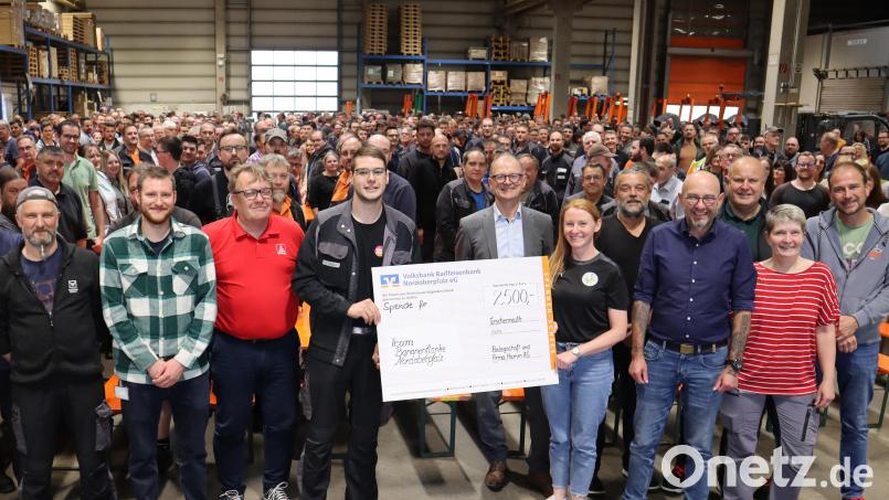 VK-Leiter Alexander Schubert (vorne, Vierter von links) überreicht an Carina Völkl (vorne, Dritte von rechts) vom Team Bananenflanke den Spendenscheck. Mit auf dem Bild Betriebsratsvorsitzender Günther Fiedler (vorne, links) und Dr. Stefan Klumpp, Vorstand Hamm AG (hinter dem Spendenscheck). Bild: Hamm AG/exb