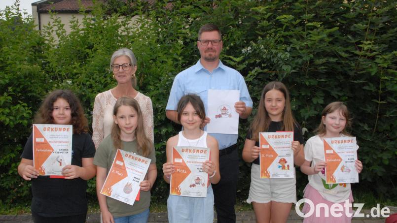 Die Gewinner des Logo-Malwettbewerbs (Mitte Siegerin Maria Sophie) mit Schulleiterin Sabine Lubich und Feuerwehr-Vorsitzendem Pit Rogga. Bild: pop