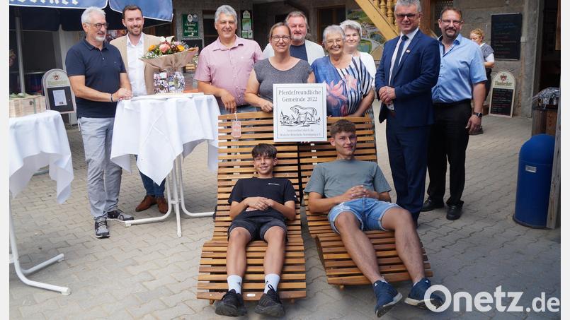 Die Ehrengäste Werner Dietrich, Johannes Lohrer (von links), Markus Greiner (rechts), Alexandra Beier (Dritte von rechts) und Hubert Obendorfer (Fünfter von rechts) übergeben zum 50-jährigen Bestehen des Kollerhofes zwei Liegen an Günter (Dritter von links), Sabine (Vierte von links) und Seniorin Monika Koller (Sechste von links). Die beiden Söhne Matthias und Johannes (von links) testen sie sogleich, und Bürgermeister Martin Birner (zweiter von Rechts) gratuliert der Familie. Bild: wel