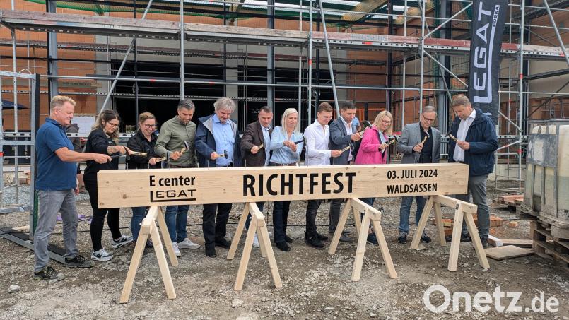 Claudia und Stefan Legat sowie Sohn Cedrik (Mitte) sowie weiterer Ehrengäste des Richtfests mussten Nägel in einen vorbereiteten Balken schlagen. Bild: pz