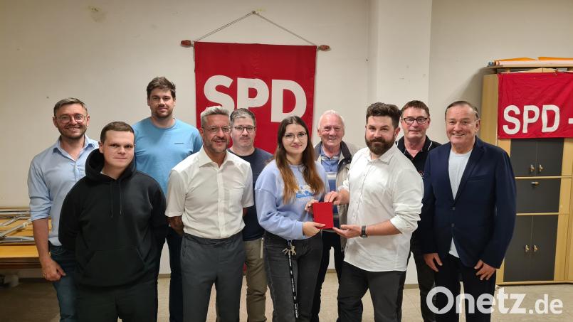 Der neue Vorstand der Neustädter SPD. Vorsitzender Sebastian Giering überreicht Lena Groz das rote Parteibuch. Bild: Martin Schmidberger/exb