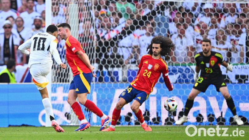 Spaniens Marc Cucurella (M) bekommt den Schuss von Deutschlands Jamal Musiala an den Arm. Bild: Tom Weller/dpa