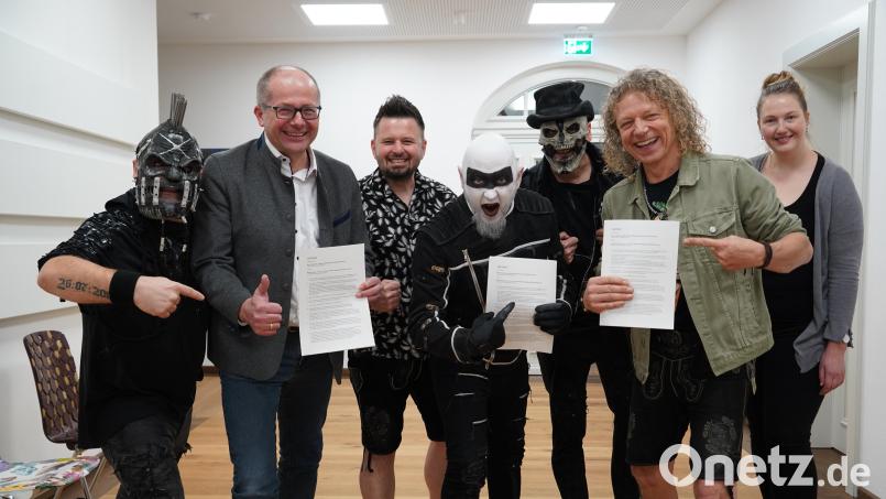 Die Metal-Band Hämatom feiert 2024 ihr 20-jähriges Bestehen mit einem Open-Air-Konzert auf dem Kemnather Stadtplatz. Die Verträge sind unterschrieben. Von links: Jacek &quot;Ost&quot; Zyla, Roman Schäffler, Thorsten &quot;Nord&quot; Scharf, Frank &quot;Süd&quot; Jooss sowie die Troglauer Mike Raps (Dritter von links), Thomas &quot;Domml&quot; Wöhrl (Zweiter von rechts) und Carolin Böckl vom Stadtmarketing. Bild: kaz