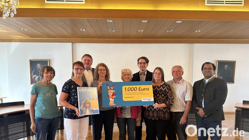 Im Sitzungssaal des Rathauses übergibt Markus Windisch (Vierter von rechts) die Spende an das Team der Stadt-und Pfarrbücherei übergeben. Pater Robin (rechts) und Bürgermeister Hans-Martin Schertl (Dritter von links) freuen sich über den Mediengutschein im Wert von 1000 Euro. Bild: Stefanie Gradl