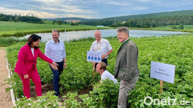 Landwirtschaftsministerin Michaela Kaniber ist begeistert von der Bewässerungsteichwirtschaft, deren Vorteile (von links) Michael Holtschulze, Projektleiter Martin Oberle sowie der Präsident der Bayerischen Landesanstalt für Landwirtschaft Stephan Sedlmayer mit (gebückt) Juniorbetriebsleiter Florian Stangl testen. Bild: Gerhard Götz