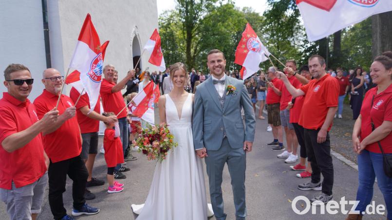 Anna-Lena und Simon Bauer schreiten nach der Trauung am Fahrenberg durchs Spalier der Bayernfans Waldthurn. Bild: fvo