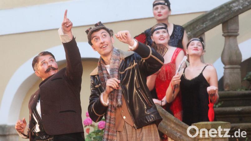 Regisseur Helmut Böhm (Fabian Wolf) verspricht Bürgermeister "Andi" (Manuela Pürzel-Lehner, links) das Blaue vom Himmel. Szene aus dem Theaterstück "Als der Film nach Schwandorf kam". Bild: Hirsch