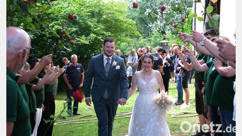 Verena und Andreas Beimler schreiten bei ihrer kirchlichen Hochzeit glücklich durchs Spalier. Bild: Renate Hilburger/exb