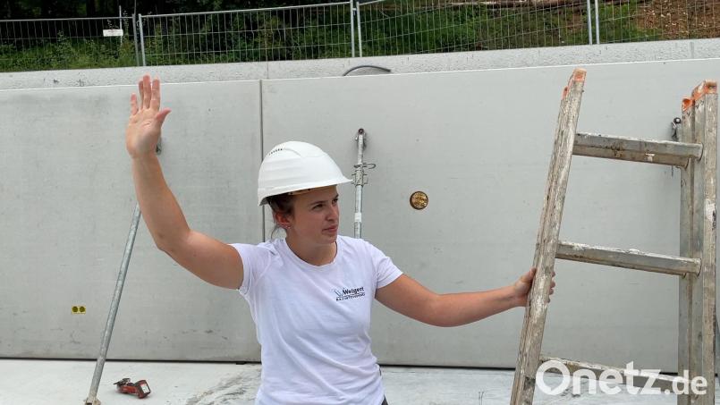 Maurermeisterin Julia Weigert aus Hohenburg weist den Kranfahrer auf der Baustelle mit Handzeichen an. Bild: Nils Ganzmann