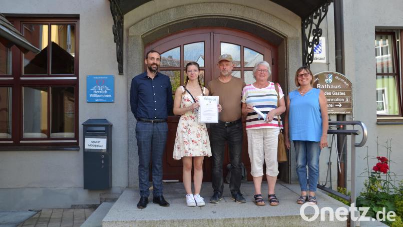 Bürgermeister Armin Bulenda (links) ehrt Familie Fussy für den 20. Aufenthalt in Moosbach, hier in Begleitung von Gastgeberin Inge Kick (rechts). Bild: Peter Garreiss