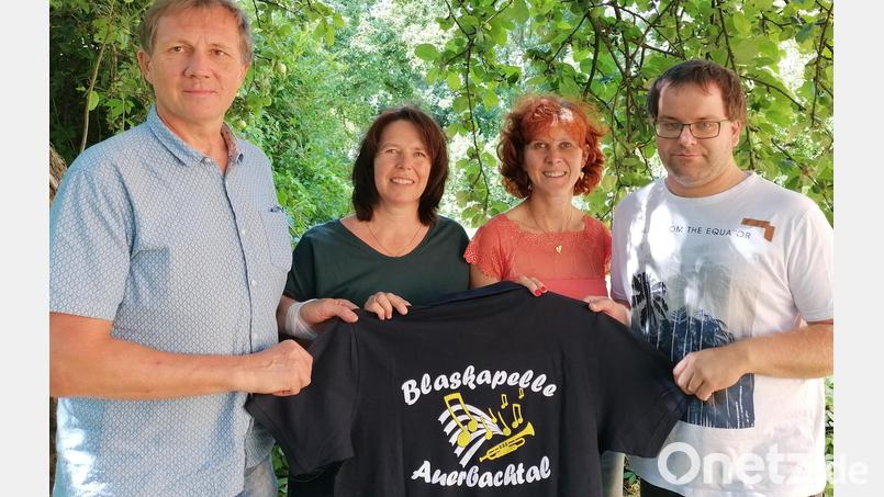 Die beiden musikalischen Leiter (rechts im Bild) und die beiden Vorsitzenden konnte die neuen Blaskapellen-Shirt mit neuem Logo präsentieren. Am Sommerabend am kommenden Samstag werden diese Shirt statt der Tracht getragen. Bild: ga