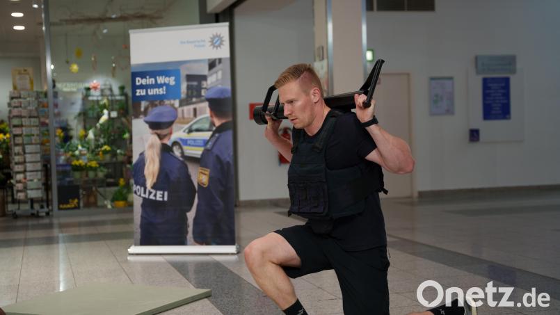 Polizei-Einsatztrainer Max macht im Erdgeschoss im Donaueinkaufszentrum in Regensburg Ausfallschritte. Mit einem öffentlichen Zirkeltraining will das Polizeipräsidium Oberpfalz über Polizeiarbeit aufklären. Bild: Jakob Graf