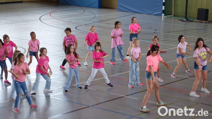 Die Grundschulmädchen sorgten für einen fulminanten Einstieg ins Sommerfest der Offenen Ganztagsschule mit ihrem Flashmob, den sie mit der Klasse 5b einstudiert hatten. Bild: u
