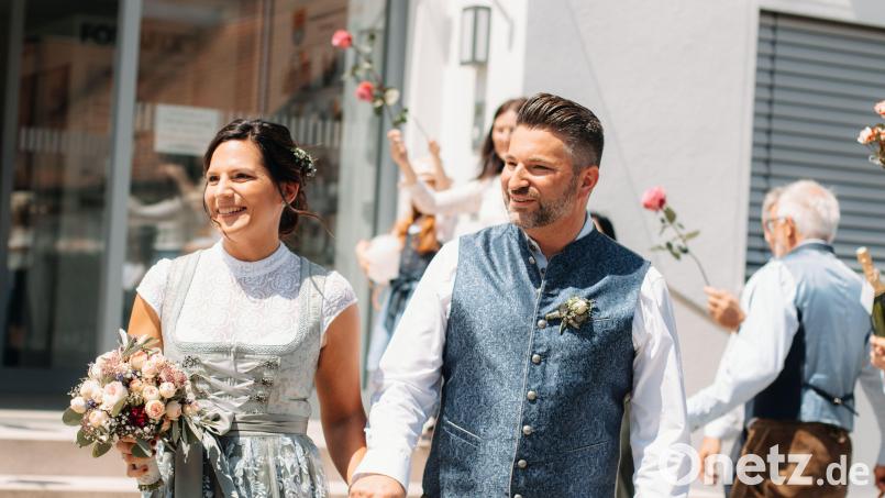 Nach ihrer Trauung in Illschwang gehen Christina Stollner und Marc Simmendinger durch ein Splaier mit Rosen.. Bild: Kristina Erker/exb