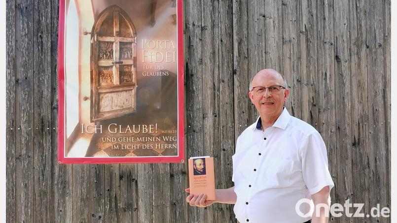 Der Teunzer Pfarrer Herbert Rösl hat eine zweijährige Ausbildung zum Exerzitienbegleiter absolviert. Das Plakat am Pfarrstodl und das Buch für geistliche Übungen begleiten ihn dabei. . Bild: Portner