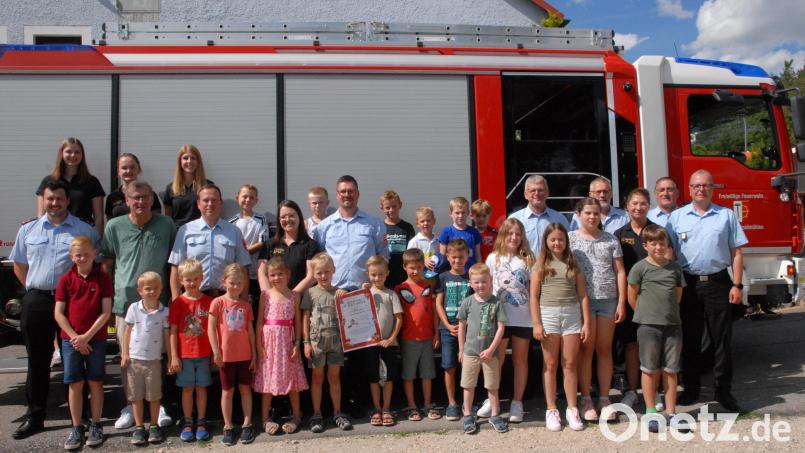 Stolz zeigten sich die Kinder mit den Aktiven der Wehr die Gründungsurkunde. Bild: pop