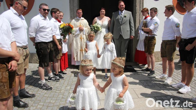 Das Brautpaar Annalena und Sebastian Härtl beim Verlassen der Kapplkirche mit den vier Brautkindern Fiona, Nora, Emilia und Josephine. Mit im Bild Kaplan Bastian Neumann und Mitglieder des Burschenvereins Konnersreuth. Bild: kro