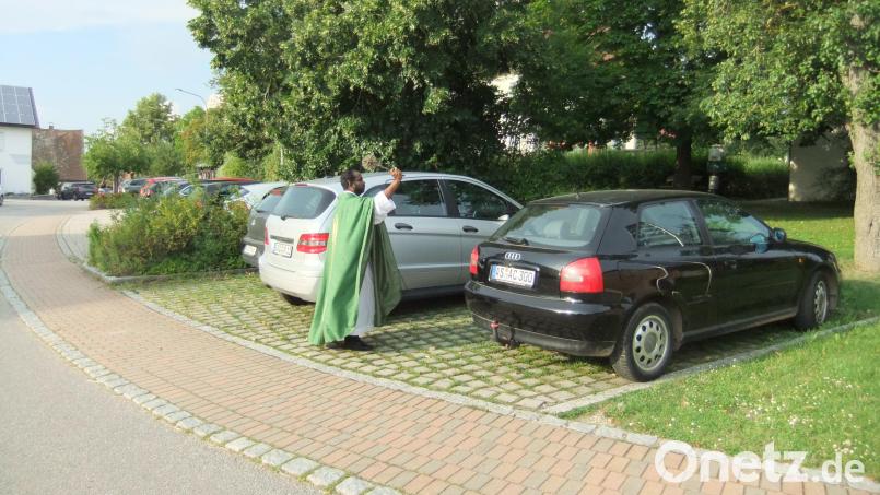 Seelsorger Sagai besprengt die Fahrzeuge mit Weihwasser im gläubigen Vertrauen darauf: An Gottes Segen ist alles gelegen. Bild: gm