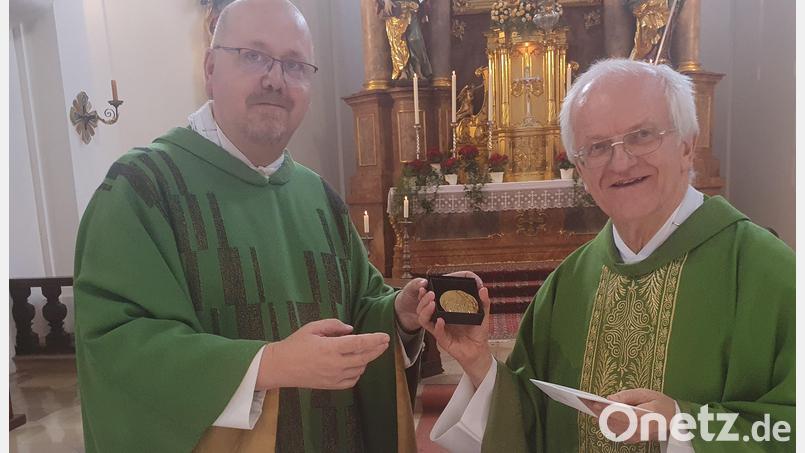 Im Namen von Bischof Rudolf Voderholzer übergibt der Weidener Prodekan Johannes Lukas (links) eine Dankesmedaille an Stadtpfarrer Josef Häring, der in den Ruhestand geht. Die Medaille stammt vom niederbayerischen Bildhauer Joseph Michael Neustifter. Bild: mas