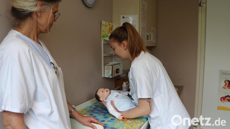 Praxiskoordinatorin Astrid Giesen (links) ist sehr zufrieden damit, wie Studentin Laura Simson das Übungspuppenbaby hoch hebt. Auch das wird während des Studiums erlernt – natürlich nicht nur an Puppen, sondern auch an echten Babys. Denn wie in der Ausbildung, ist im Studium in Regensburg der Kontakt zum Patienten sehr wichtig. Bild: Nina Kalmus