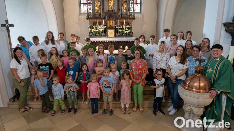Kinder und Pfarrer Berthold Heller (rechts) verabschieden die Leiterin der Einrichtung St. Wolfgang Gabriele Bösl-Mrazek (vorne, Mitte). Bild: Alfred Bäumler