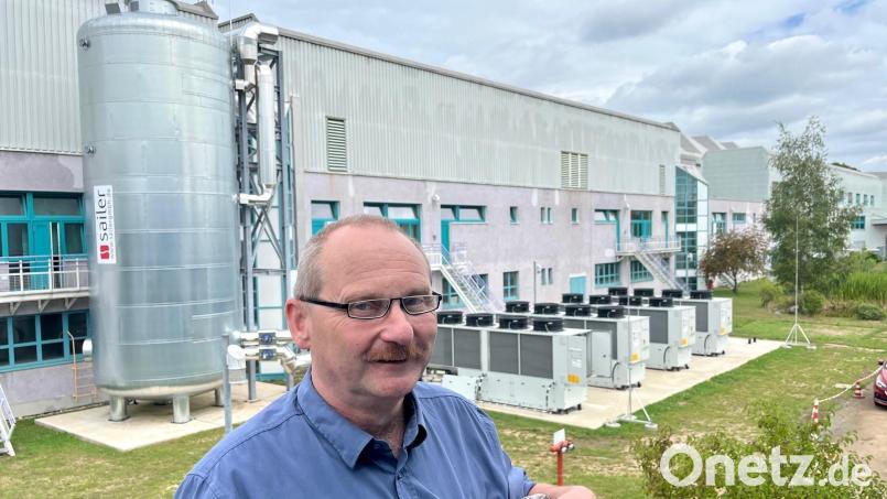 Karl Herrmann und die vier Wärmepumpen der neuen Heizanlage bei der OWS GmbH in Weiden. In dem Metallzylinder links ist der Pufferspeicher untergebracht. Bild: Gabi Schönberger
