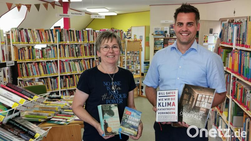 Zwei Romane, ein Sachbuch und ein Bildband aus über 14 000 Medien der Stadtbibliothek Oberviechtach: Bürgermeister Rudolf Teplitzky und Leiterin Renate Stigler präsentieren ihre Buchempfehlung für den Sommerurlaub. Bild: Portner