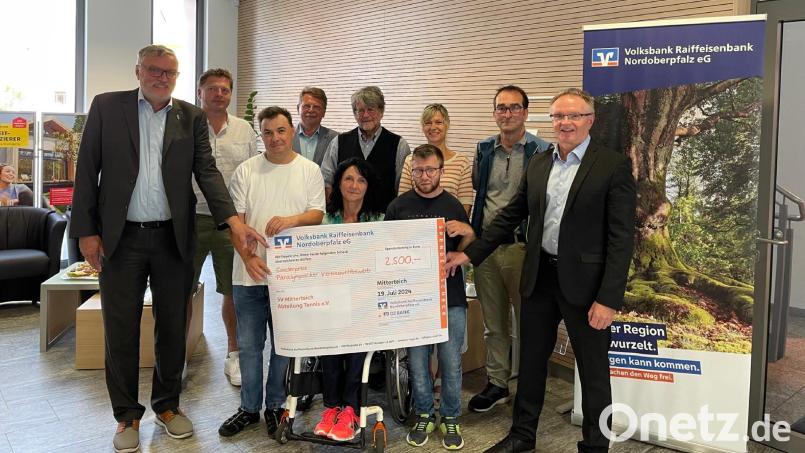 In der Mitterteicher Geschäftsstelle der Volksbank Raiffeisenbank Nordoberpfalz nahmen Mitglieder der Tennissparte des SV Mitterteich um Doris Scharnagl-Lindinger (vorne, Mitte) und Friedrich Wölfl (hinten, Mitte) den Scheck über 2500 Euro entgegen. Mit im Bild Jürgen Wagner (links) als Vertreter der DZ-Bank und Harald Zottmeier (rechts), Regionalmarktleiter der Volksbank Raiffeisenbank Nordoberpfalz. Bild: Nico Wolf, Volksbank Raiffeisenbank Nordoberpfalz/exb