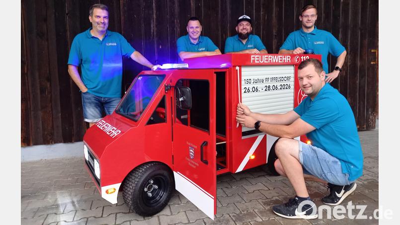 Feuerwehr-Vorsitzender Michael Kiener, Stellvertreter und Festleiter Christian Kalb, Stefan Kiener und Thomas Schreier (von links) sowie Johannes Kiener (im Vordergrund) haben sich fürs Jubiläum ein ganz besonderes Fahrzeug einfallen lassen. Bild: bl