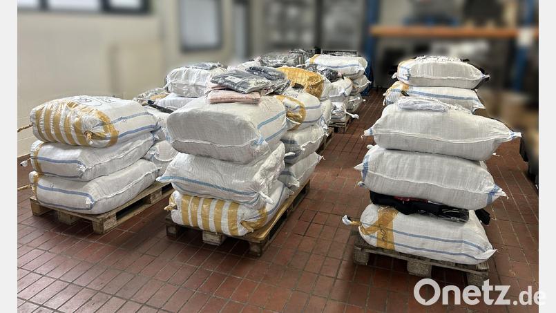 In einer Lagerhalle des Zolls in Hof lagern die sichergestellte Kleidung. Bild: -/Hauptzollamt Regensburg/dpa