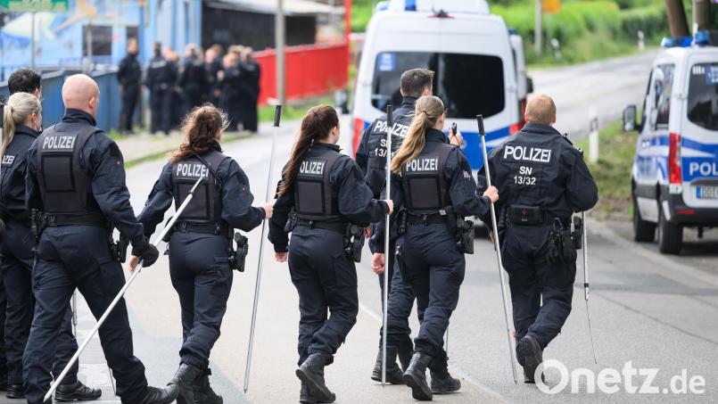 Polizisten sind mit Suchstangen im Einsatz. Symbolbild: Robert Michael/dpa