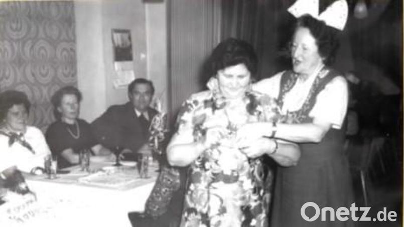 Bei einer der ersten Veranstaltungen nach der Gründung verleiht Vorsitzende Rosa Böhm (rechts) Kassiererin Anna Zwack einen Orden; im Hintergrund der damalige Pfarrer Johann Nesner. Bild: Betty Wölfel/exb