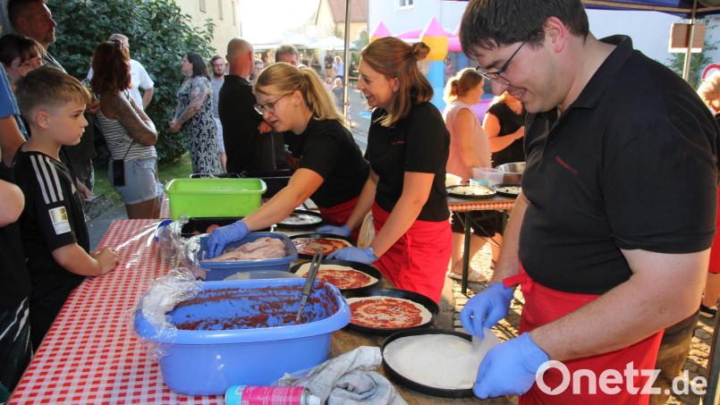 Das Pizzateam beim Belegen der Pizzas. Bild: kro