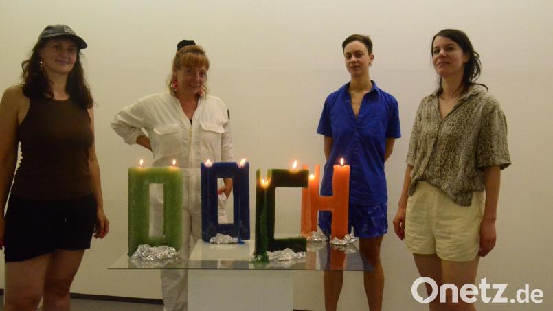 Sobald der Docht runtergebrannt ist, löst sich das Wort &quot;D.O.C.H.&quot; in einer flächendeckenden Wachsschicht auf. Kuratorin Carolin Schiml (Zweite von rechts) vom Kunstverein stellt die Künstlerinnen vom Künstlerhaus Bremen vor. Bild: Kunz
