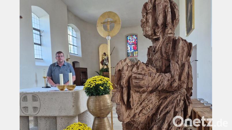 Die Skulptur &quot;Tragen und getragen werden&quot; stellt der Klardorfer Pfarrer Markus Meier (am Altar) in der Klardorfer Kirche St. Georg aus. Bild: td