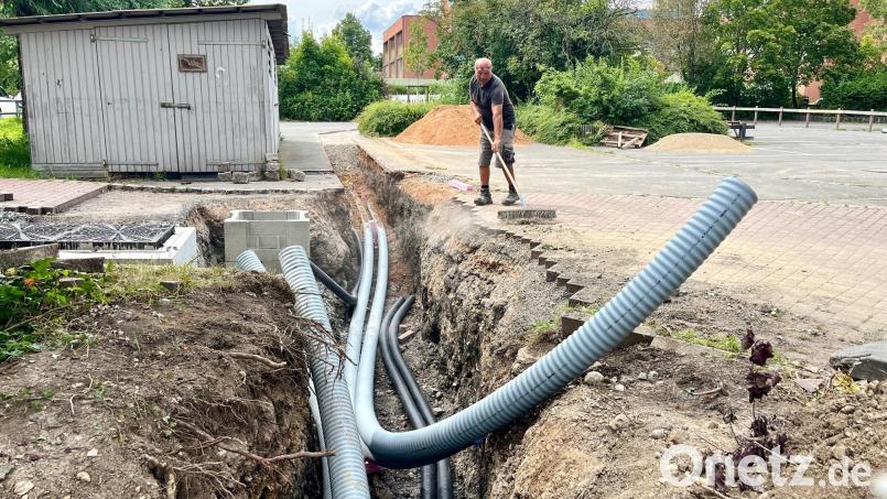 Der Pausenhof der Realschule ist Baustelle. Die Tiefbaufirma Schieder, Bechtsrieth, und Mitarbeiter der Stadtwerke Weiden nutzen die Ferien, um Fernwärmeleitungen für den Anschluss des Neuen Rathauses (im Hintergrund) zu verlegen. Bild: Gabi Schönberger