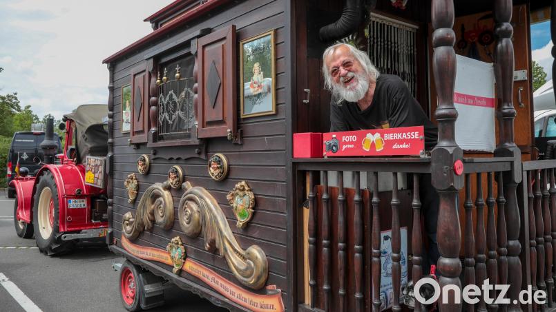 Fritz Schmid auf der winzigen Veranda seines Oldtimer-Gespanns auf dem Wohnmobilstellplatz in Amberg. In der &quot;Bierkasse&quot;, auf die das rote Schild hinweist, hinterlassen Passanten oft &quot;Trinkgeld&quot; für ein Foto. Bild: Wolfgang Steinbacher