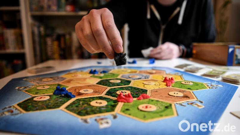 Spieler spielen das Spiel &quot;Siedler von Catan&quot;. Symbolbild: Britta Pedersen/dpa