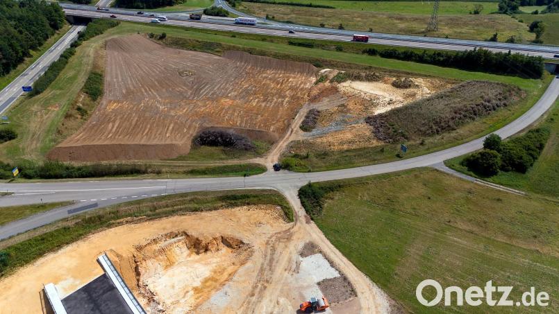 Bei Theuern beginnen die Straßenbauarbeiten für die Kümmersbrucker Westumgehung. Das neue Baufeld ist die dunkelbraune Fläche im oberen linken Teil des Bildes, quer dahinter verläuft die Autobahn A6 und schräg durch die Bildmitte die Kreisstraße nach Theuern. Am linken Bildrand zu erkennen ist die Vilstalstraße, im unteren linken Drittel, auf der hellbraunen Baufläche, sieht man noch eine Ecke der bereits fertiggestellten Brücke. Bild: hbe