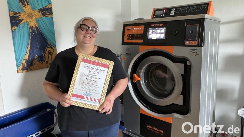 Michaela Sack mit ihrem Tatortreiniger-Zertifikat und ihrem ganzen Stolz: der Spezialwaschmaschine Berta. Bild: Matthias Bäumler